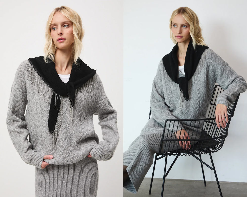 Mladá žena szürke kötött pulóverben és fekete sálban, modern háttér előtt.